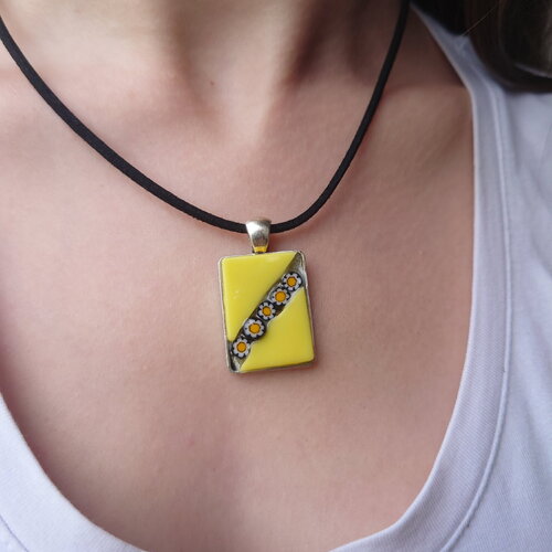 Pendentif rectangle en céramique jaune avec diagonale de millefiori marguerite bordés de noir. bijou artisanal unique.