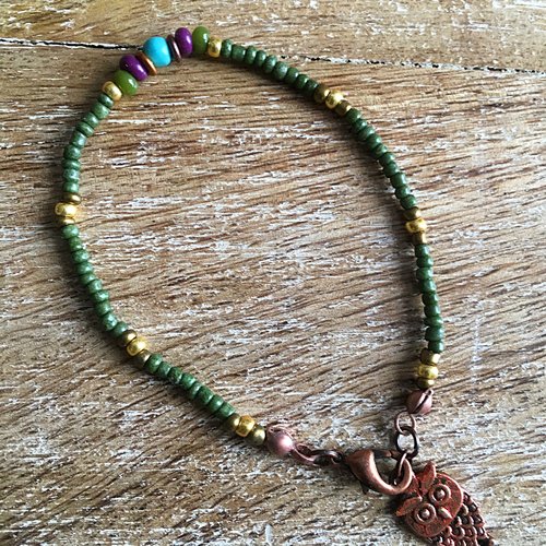 Vendu.bracelet fin gujo en rocailles kaki et breloque chouette cuivrée.