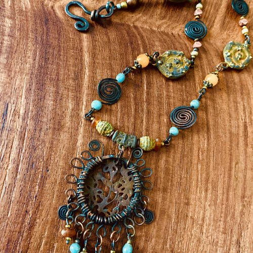 Collier ethnique mi long médaillon grille de fleurs traité effet rouille, perles ambre et turquoise.