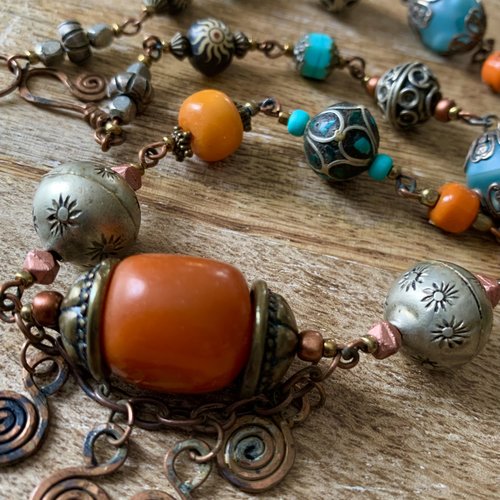 Collier mi-long ethnique en ambre, perles du tibet et en métal argenté montées sur une chaîne de cuivre.