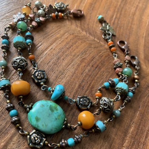 Bracelet ethnique 3 rangs séparés autour d'une grosse perle en turquoise, en ambre et argentées.