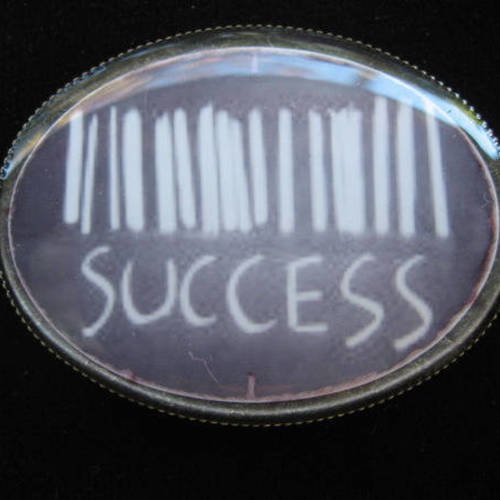 Broche ovale fantaisie, code barre success, sertie en résine / taille 30mmx40mm