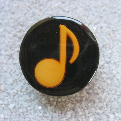 Bague fantaisie, note musicale orange, sur fond noir en résine / diamètre 25mm