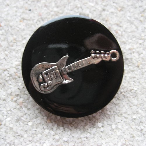 Grande bague fantaisie, guitare argentée, sur fond noir en résine / diamètre 35mm