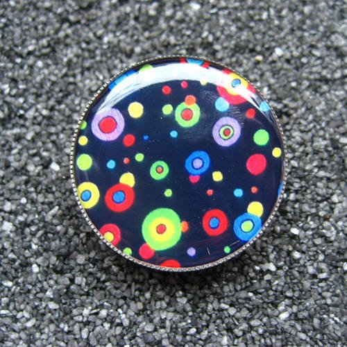 Petite bague unisexe pois multicolores sur fond noir sertie en résine diamètre 25mm