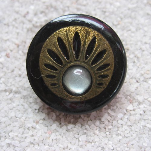 Petite bague ajustable unisexe estampe bronze et perle blanche sur fond noir en résine diamètre 25mm