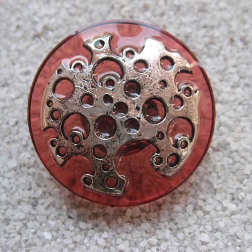 Grande bague ajustable unisexe estampe argentée trouée sur fond rouge pâle en résine diamètre 35mm