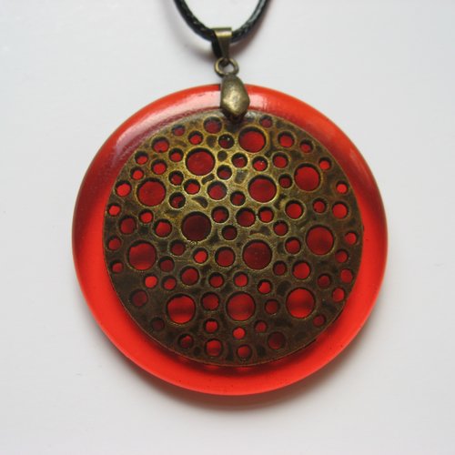 Pendentif graphique unisexe estampe bronze trouée sur fond orange en résine diamètre 40mm