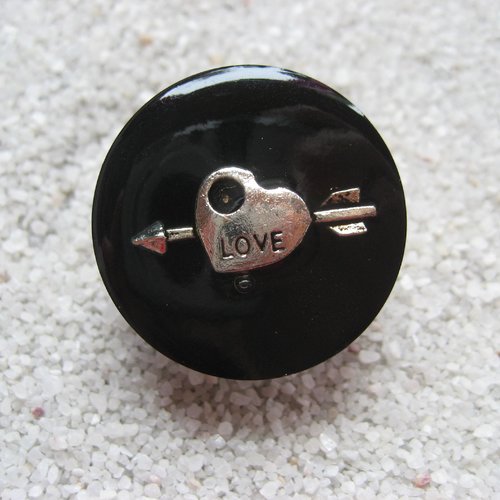Bague ajustable unisexe estampe argentée coeur fléché sur fond noir en résine diamètre 25mm