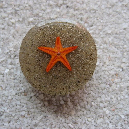 Bague ajustable unisexe étoile de mer orange sur fond de sable en résine diamètre 25mm