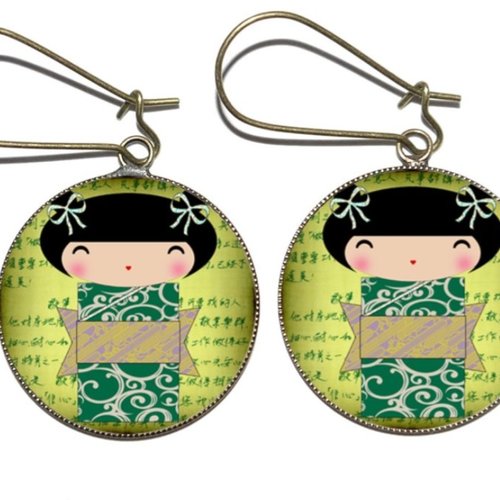 Boucles d’oreilles bronze motifs * kokeshis sur fond vert * recouverts de cabochons en résine