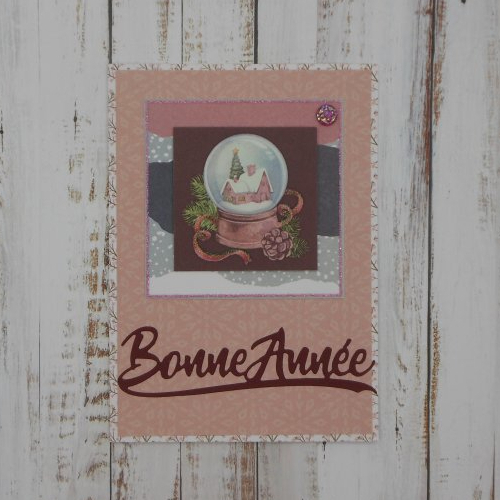 Carte de voeux bonne année village dans une boule à neige tons roses