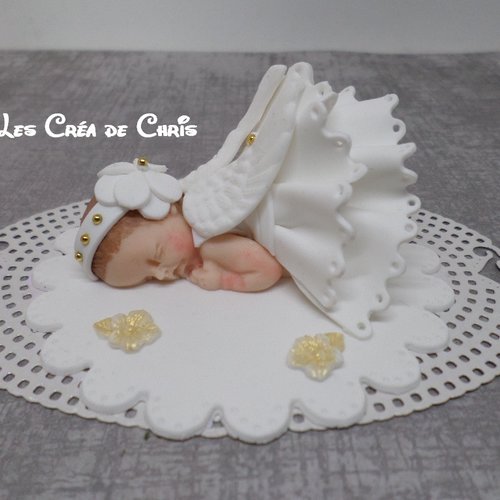 Support avec son bébé tenue de baptême ange.