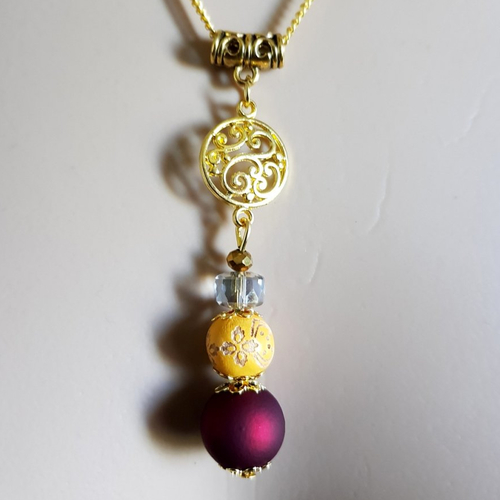 Collier pendentif rosace, perles en bois jaune, bordeaux foncé et verre transparente, chaîne, métal doré