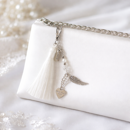 Bijou de sac – pompon blanc ailes d’ange chic