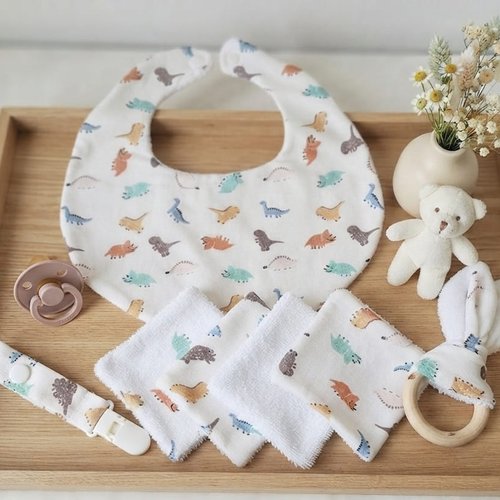 Ensemble naissance, bavoir, hochet, attache tétine et 12 lingettes blanche motifs dinosaures