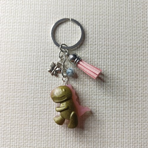 Porte-clés artisanal "dino doré & rose" — papillon & pompon