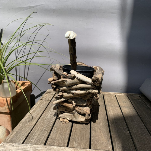 Brosse de toilettes dans pot en métal noir,  caché dans le bois flotté