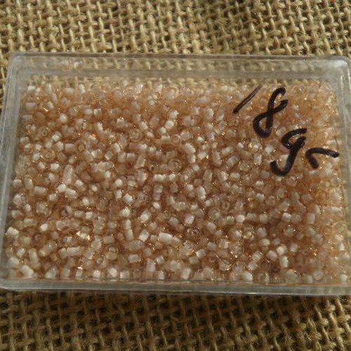 Boite de 18 grammes de perles de rocailles semi transparentes , taille 2 mm  , coloris rose chair