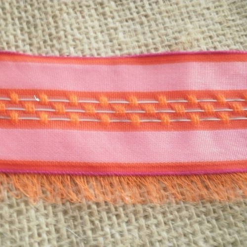 Ruban  en synthetique  , rayé rose , orange  et argenté avec des petites franges en fil orange  , taille 4 cm 