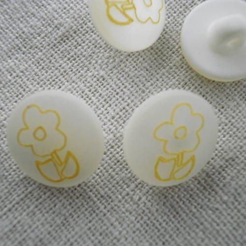 Bouton rond  en  plastique , de  couleur  blanche nacré  , motif petite fleur jaune sur le dessus 