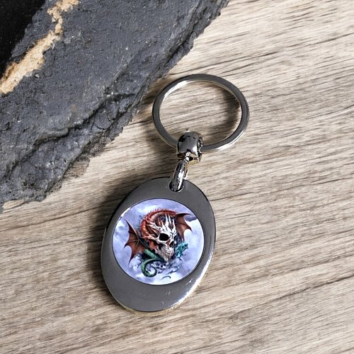 Un porte clés porte jetons élégant avec son joli motif, un crâne avec des dragons.