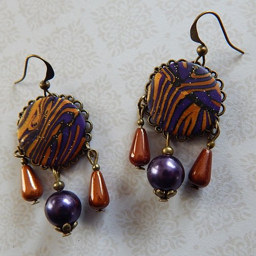 Boucles d' oreille pendantes violettes et bronze.