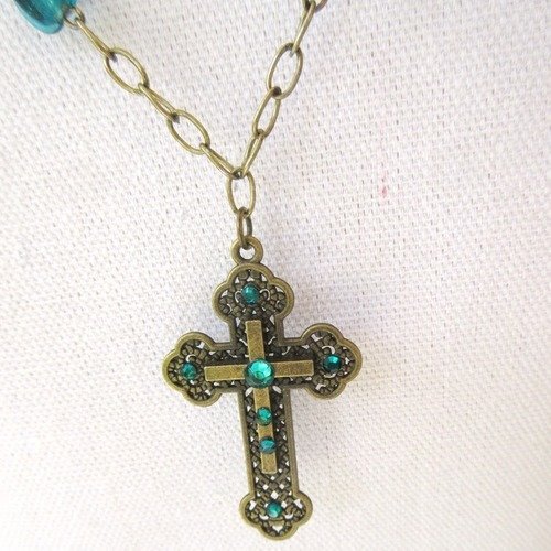 Vendu .....révélations : un collier mi-long, un peu baroque, avec croix bronze et strass vert ....