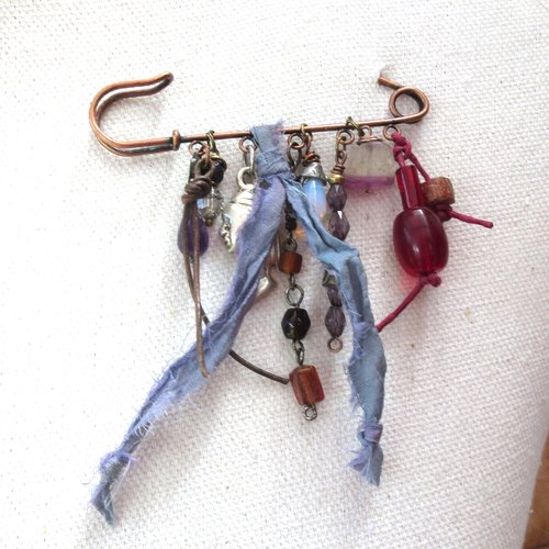 Une broche grigris avec petits trésors , pierres fines, perle en verre duch dogon : "spirales de matières"