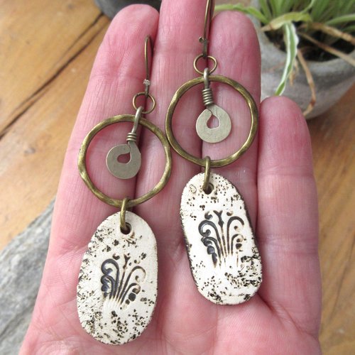 Des boucles d'oreille nomades natures; de style créoles avec des breloques en céramique artisanale : "raffinements particuliers"