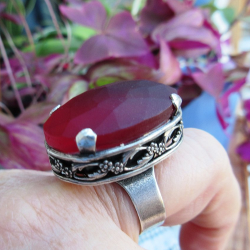 Une bague rare vintage "j.l. blain" ,  ajustable en métal argenté , avec cabochon verre facetté couleur grenat ...