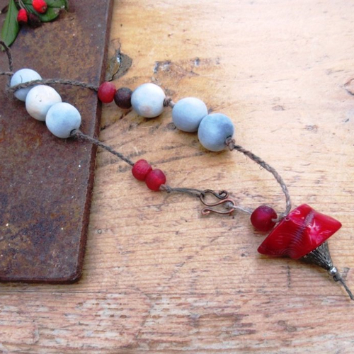 Un collier mi-long style zen, ethnique, avec céramique faïence artisanale , grosse perle en corail : "lit de corail "....
