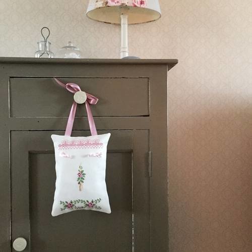 Un coussin de porte brodé de petites fleurs.