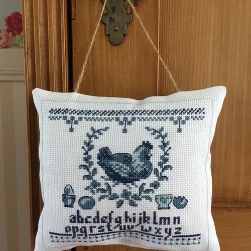 Coussin de porte ou d'armoire brodé aux points de croix 