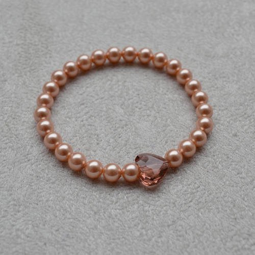 Bracelet en perles nacrées &quot; rose peach pearl &quot; et coeur en cristal de swarovski véritable sur fil élastique 