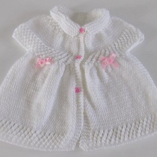 Robe bébé tricotée main , coloris blanc noeuds et boutons roses , taille 3/6 mois.