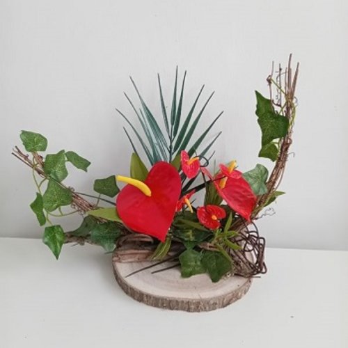 Bouquet floral exotique ( fleurs anthuriums) sur grand rondin de bois - centre de table