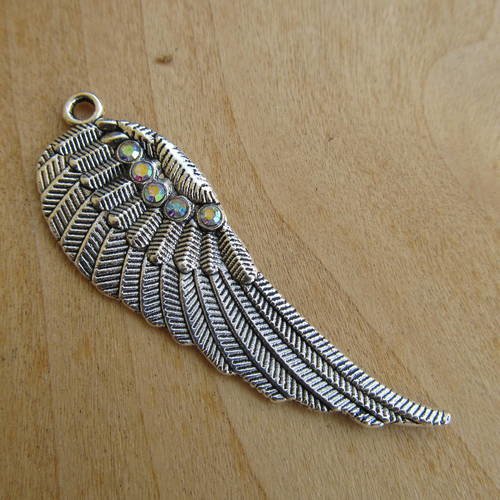 *pendentif en forme d'aile de 52 x 17 mm en métal argenté et strass irisés.