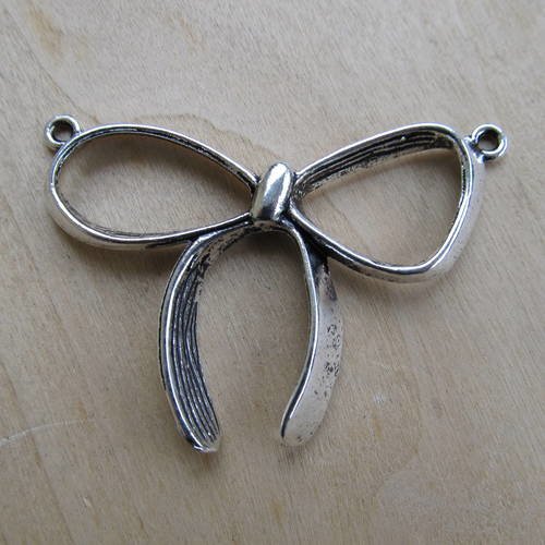 *pendentif en forme de nœud de  59 x 40 mm en métal couleur argent vieilli.