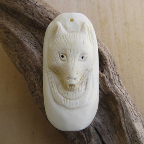 Grand pendentif de 58 x 28 x 9 mm en os, au motif de tête de loup sculptée à la main. 