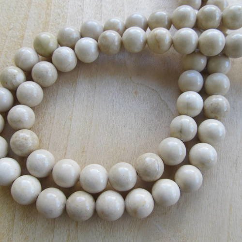 Lot de 10 perles de 10mm en pierre fossile de couleur blanc ivoire. 
