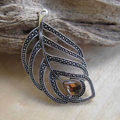 *très joli pendentif en forme de plume ajourée de 54 x 31 x 5 mm en métal argenté et strass.