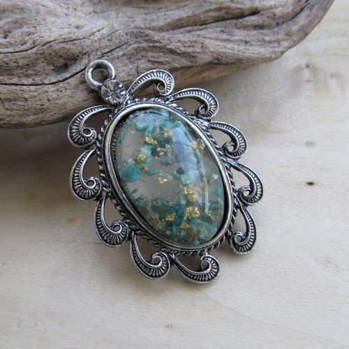 *grand pendentif de forme ovale de 55 x 39 x 8.5 mm en métal avec cabochon et d'un strass.