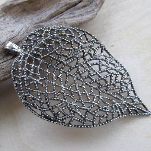 *grand pendentif en forme de feuille de  85x51x5mm en métal filigrané.