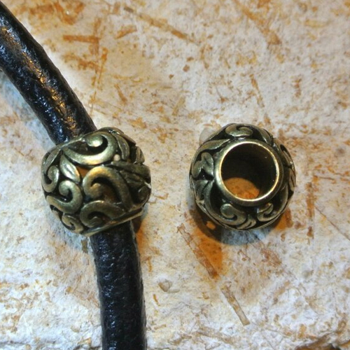 Une jolie perle passante 12 mm, ronde, motifs arabesques ou floraux, en métal couleur bronze antique