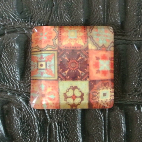 Un très joli cabochon carré, 25 x 25 mm, dôme bombé 6 mm en verre motifs carrés tons orange, vert, marron