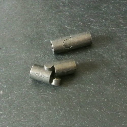 Un fermoir aimant en acier inoxydable ton gris semi-mat, forme tube, pour cordon rond de 5,5 mm, 22 x 8 mm, trou : 6 mm