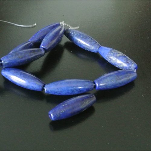 Longue perle en pierre de gemme bleu nuit et irrégularités sombres forme oblongue ou olive, 30 x 10 mm