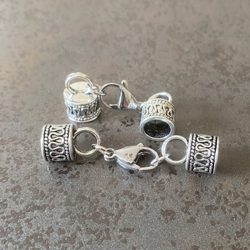 Un set (b) composé de 2 embouts décor arabesques et 1 fermoir mousqueton ton argent platine pour cordon 6,5 mm