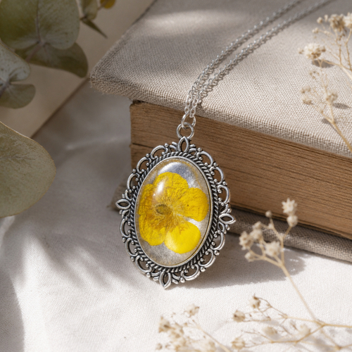 Collier botanique argenté avec fleur jaune naturelle – pendentif ovale en résine